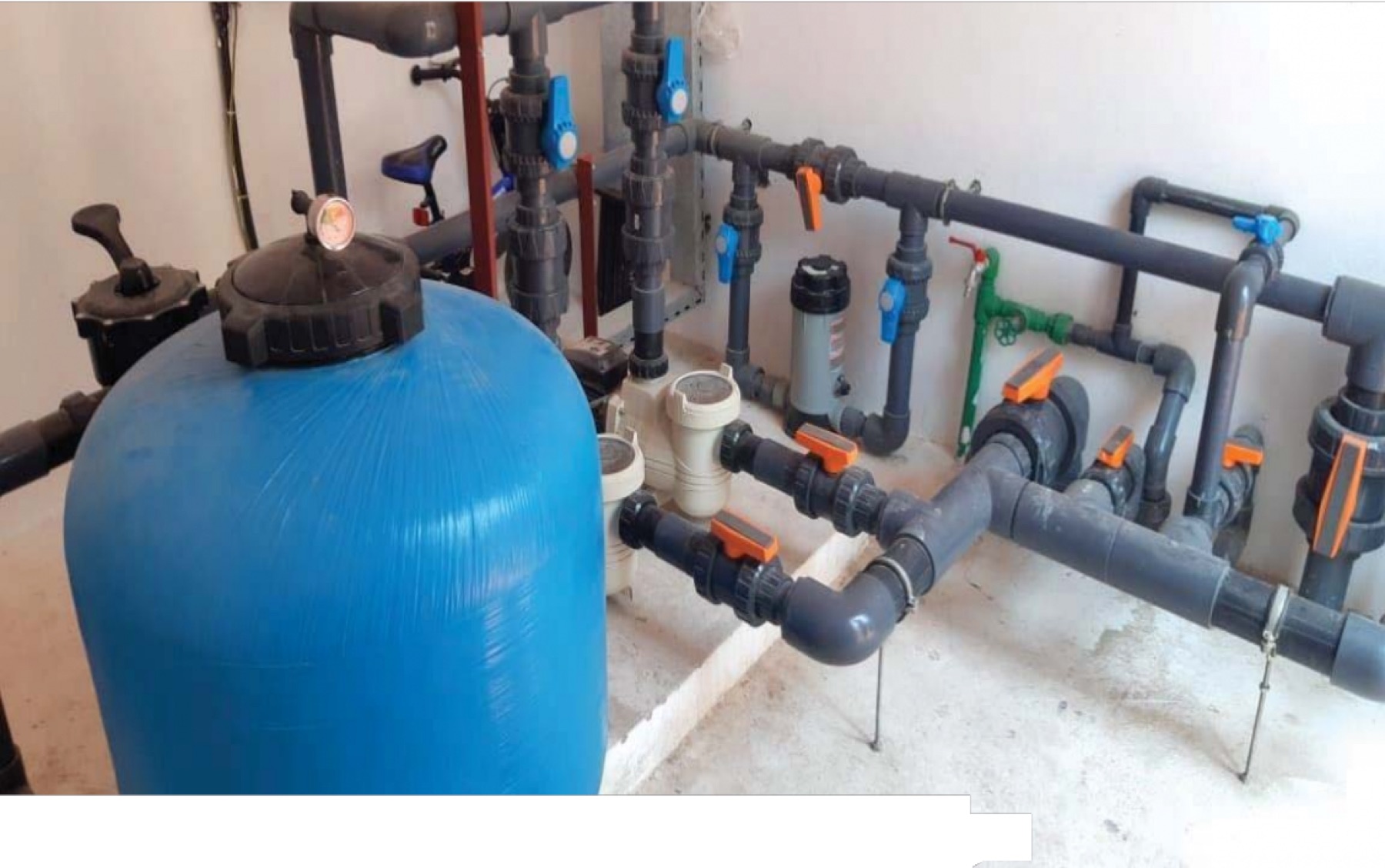 Swimming pool plant room with filtration vessel and valve manifold at Nakhliyat villas, Sharjah